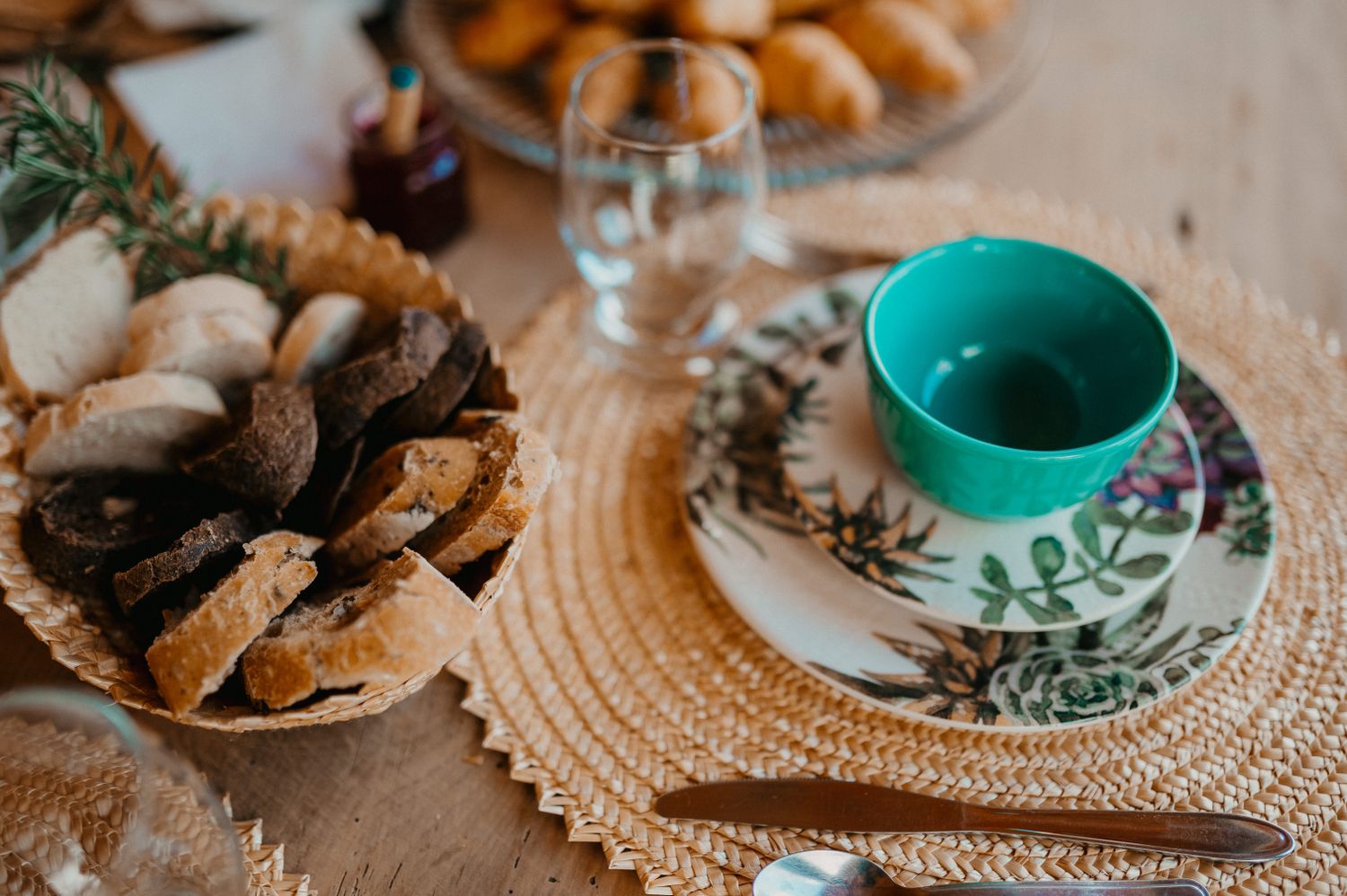 Breakfast on the wooden table: bread, pastries and jam
