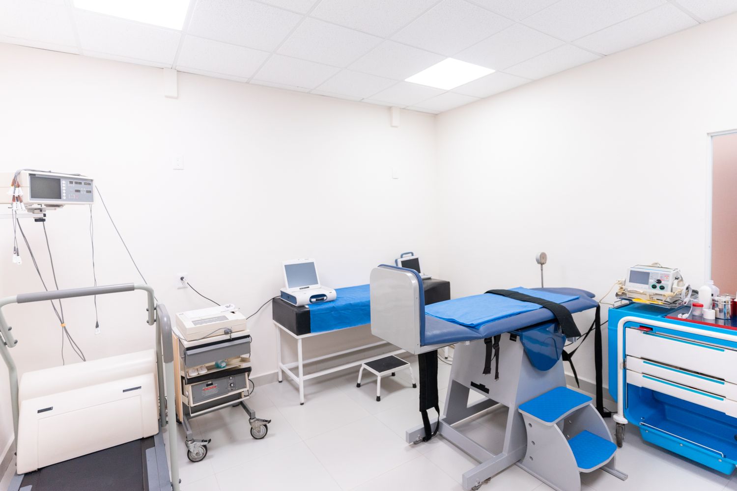 Bright room with a treatment couch and therapy equipment.