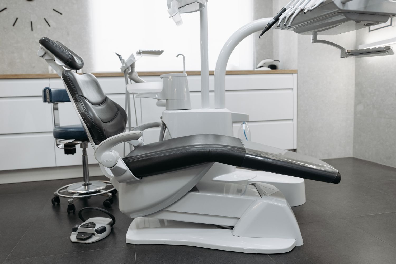 A reclined dental chair in a light grey room.