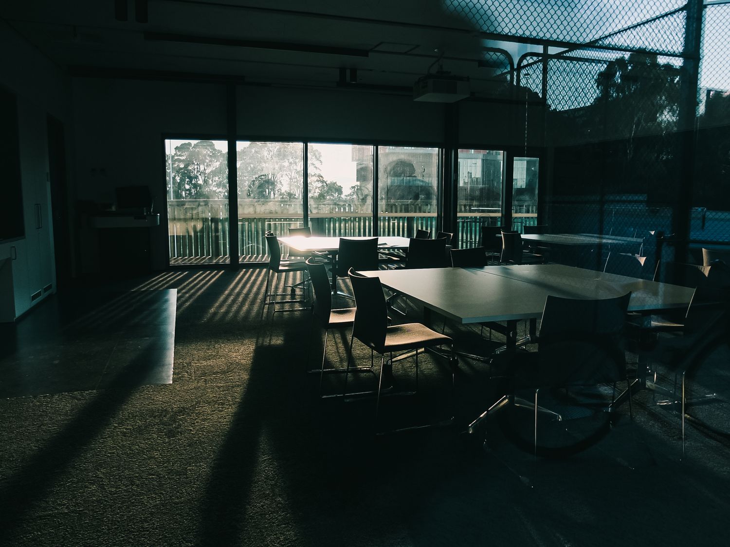 Empty meeting room with long shadows from a sunny window.