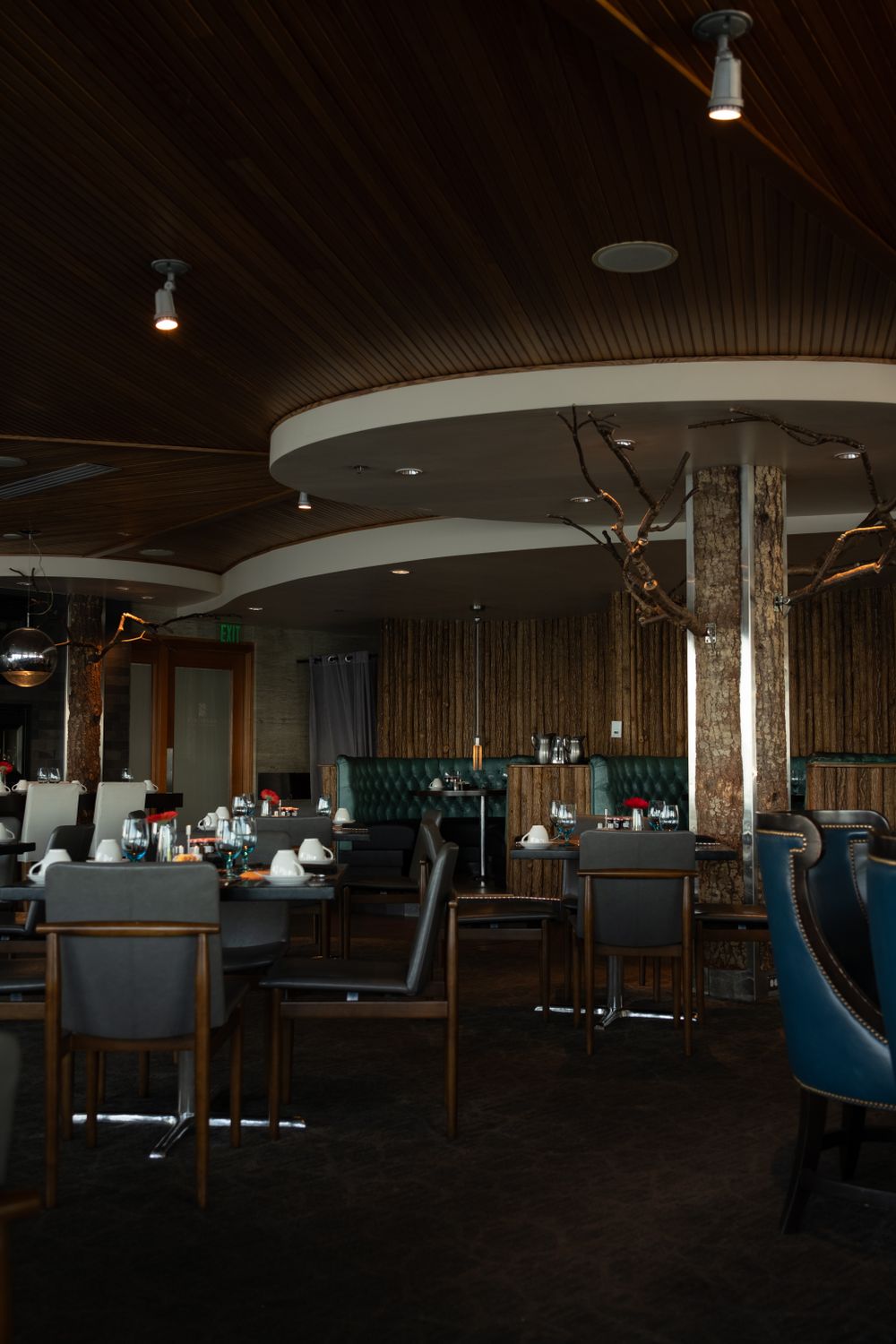 Restaurant dining room with a curved wooden ceiling and low lights.