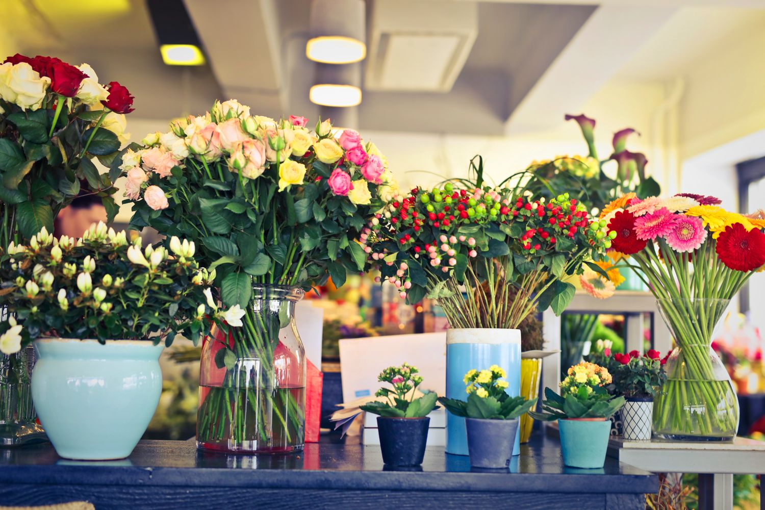 Bunches of fresh flowers in vases and buckets inside the shop.